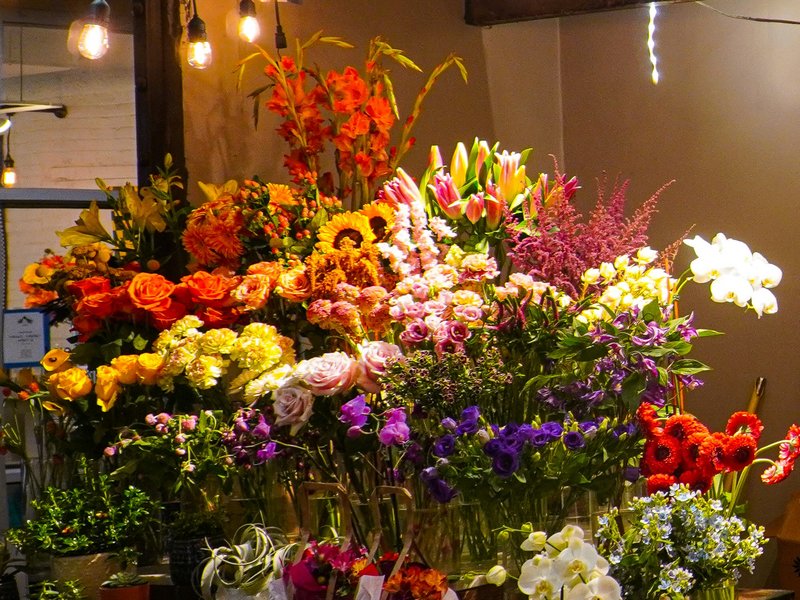 バラ・ガーベラ・ひまわりなど色とりどりの切り花が並ぶ店頭の陳列