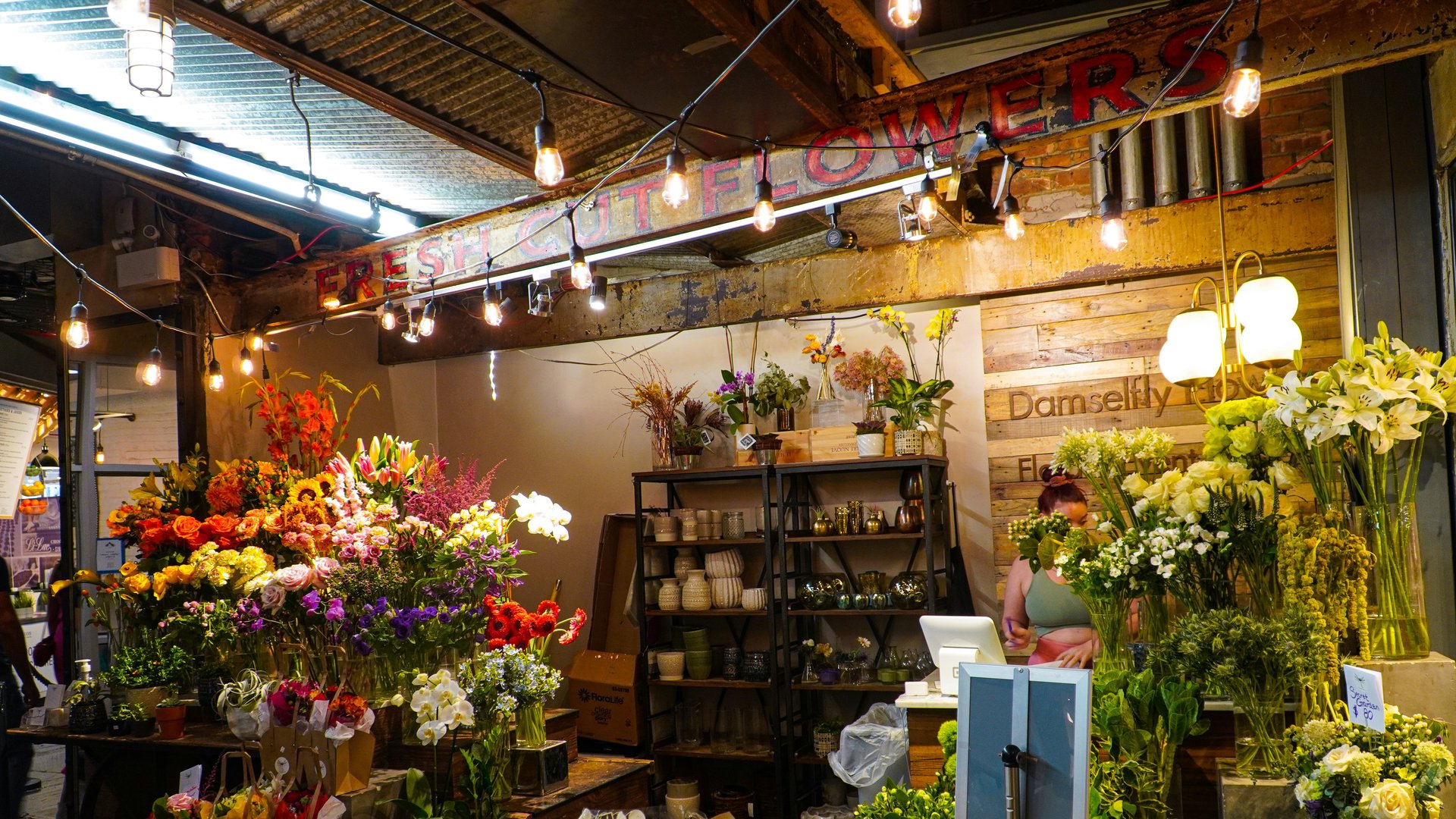 電球の灯りに照らされた店内。色とりどりの切り花が並ぶ花屋の売り場